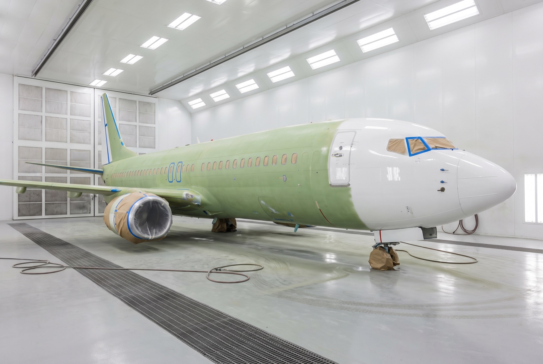 Commercial airliner masked and in primer inside an aircraft paint hangar
