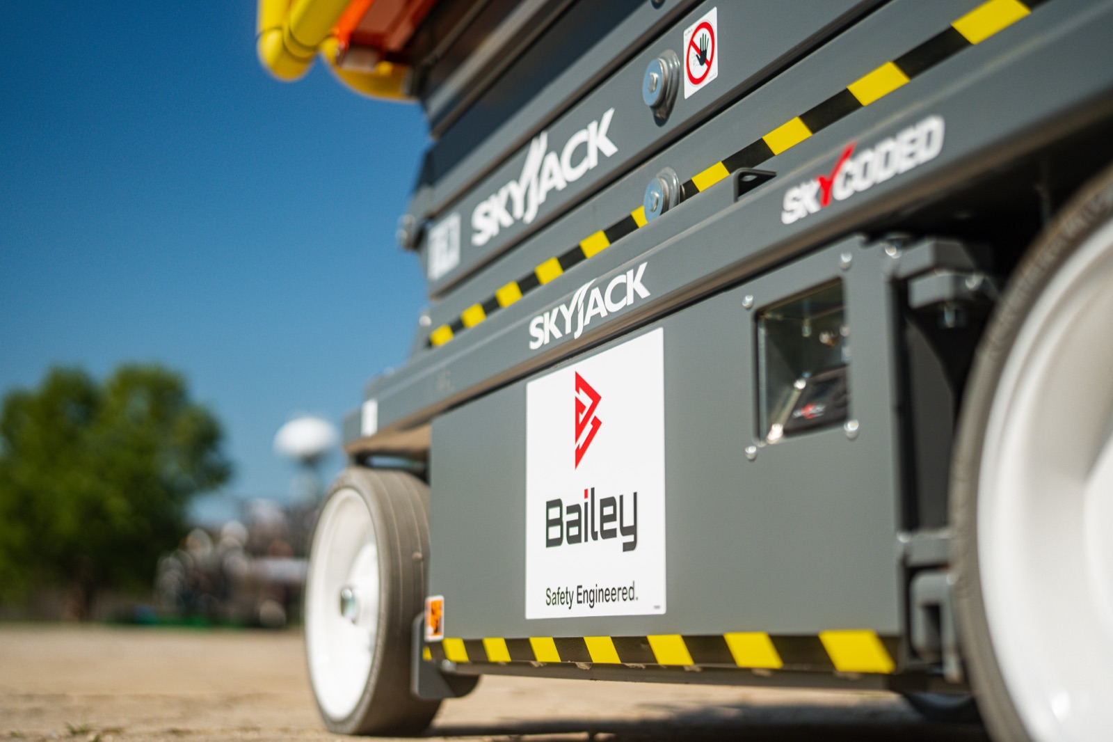 Low-angle view of a Bailey Safety Engineered scissor lift chassis, scissor stack, and drive wheels