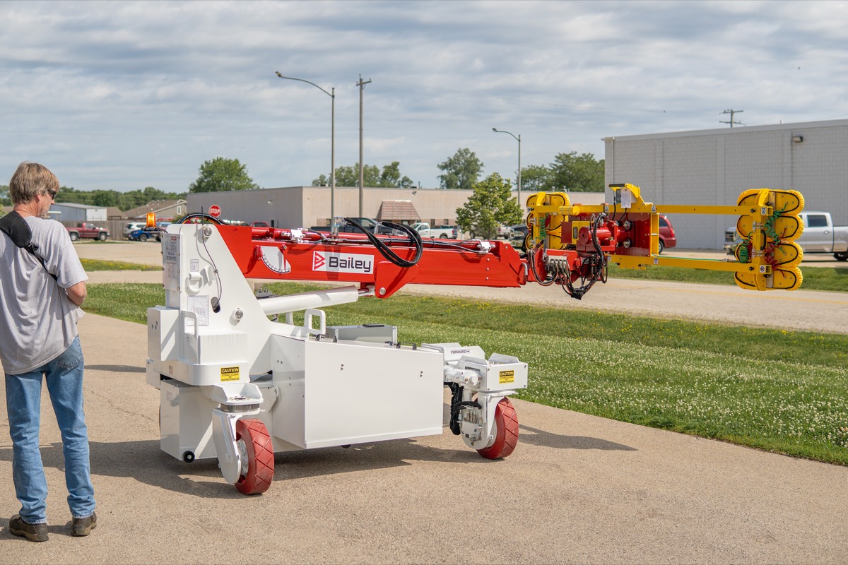 Bailey CH 6 OMNI compact handler shown next to an operator for scale, illustrating its doorway-friendly footprint