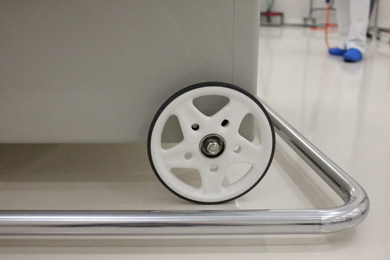 Non-marking wheel and stainless rail of cleanroom-rated lift equipment on a white cleanroom floor