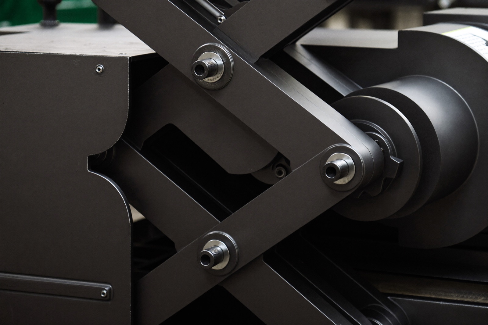 Close-up of a dual-stage double scissor lift mechanism with hydraulic cylinder and pivot pins