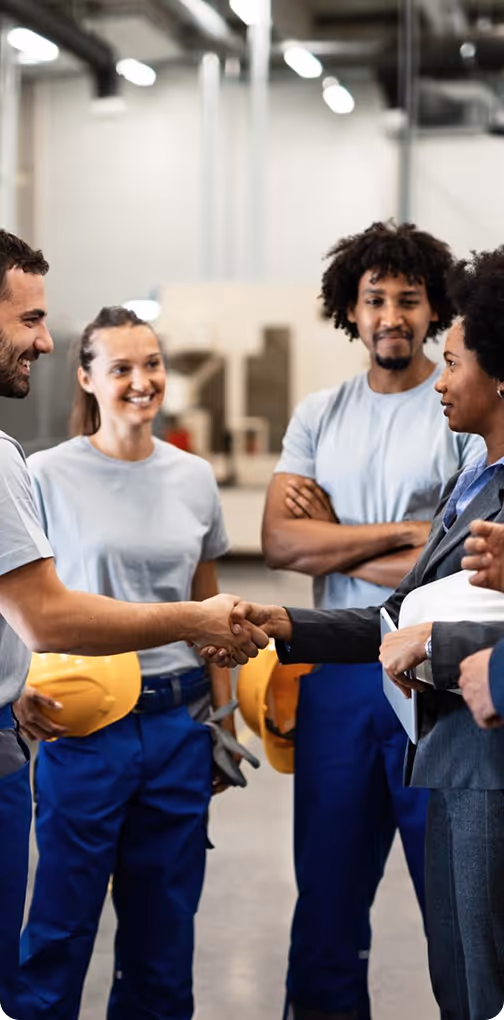 Bailey Cranes team members shaking hands inside the workshop